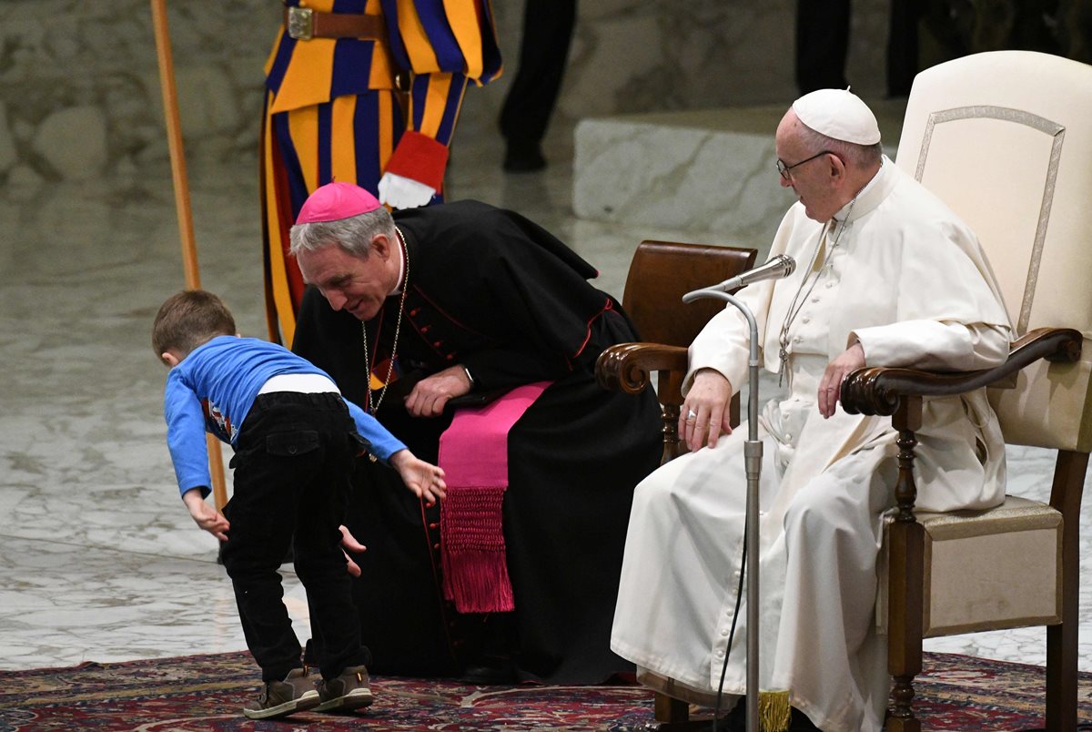 El papa Francisco y el prefecto de la casa papal, Georg Ganswein interactúan con el niño.