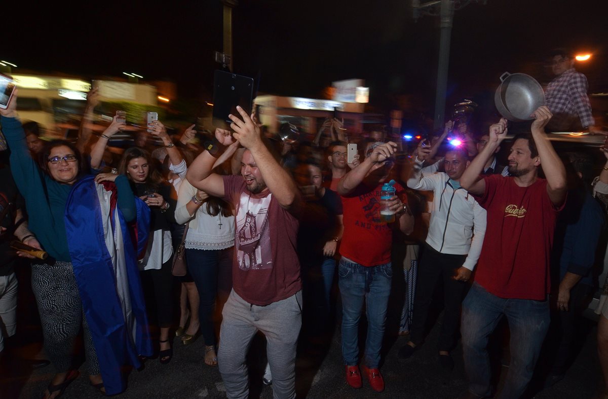 Un grupo de cubanos celebra este sábado a las afueras del restaurante Versalles, en Miami, tras el fallecimiento del líder cubano Fidel Castro a sus 90 años de edad. (Foto Prensa Libre: EFE)