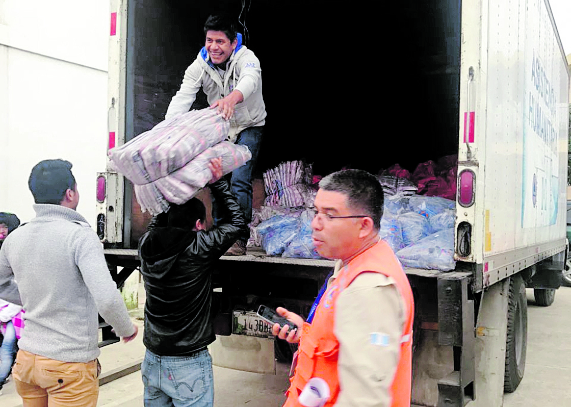 Delegados de la Coordinadora Nacional para la Reducción de Desastres y la Municipalidad de Huehuetenango descargan raciones.(Foto Prensa Libre: Mike Castillo)