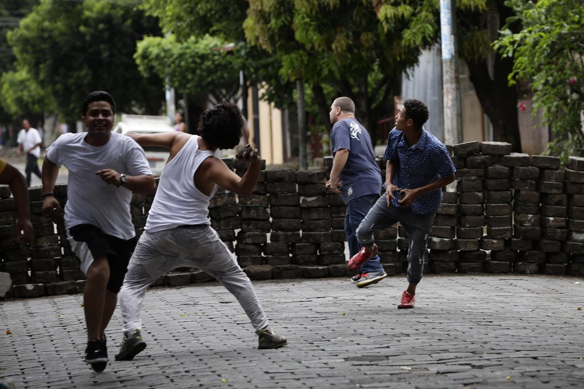 Manifestantes lanzan piedras durante enfrentamientos con la Policia Nacional en los barrios de Managua, Nicaragua.(EFE).