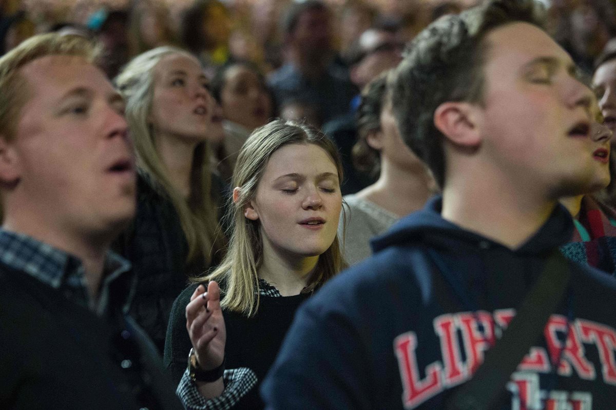 Un grupo de jóvenes canta rock cristiano durante el acto en el que Donald Trump se presentó. (Foto Prensa Libre: AFP).