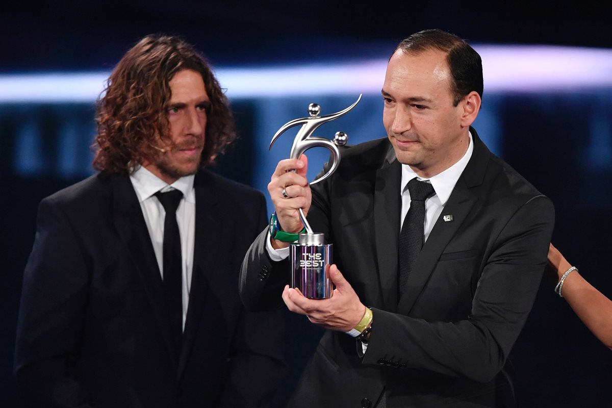 Carles Puyol entrega a Juan Carlos de la Cuesta, del Atlético Nacional, el premio Fair Play. (Foto Prensa Libre: AFP)