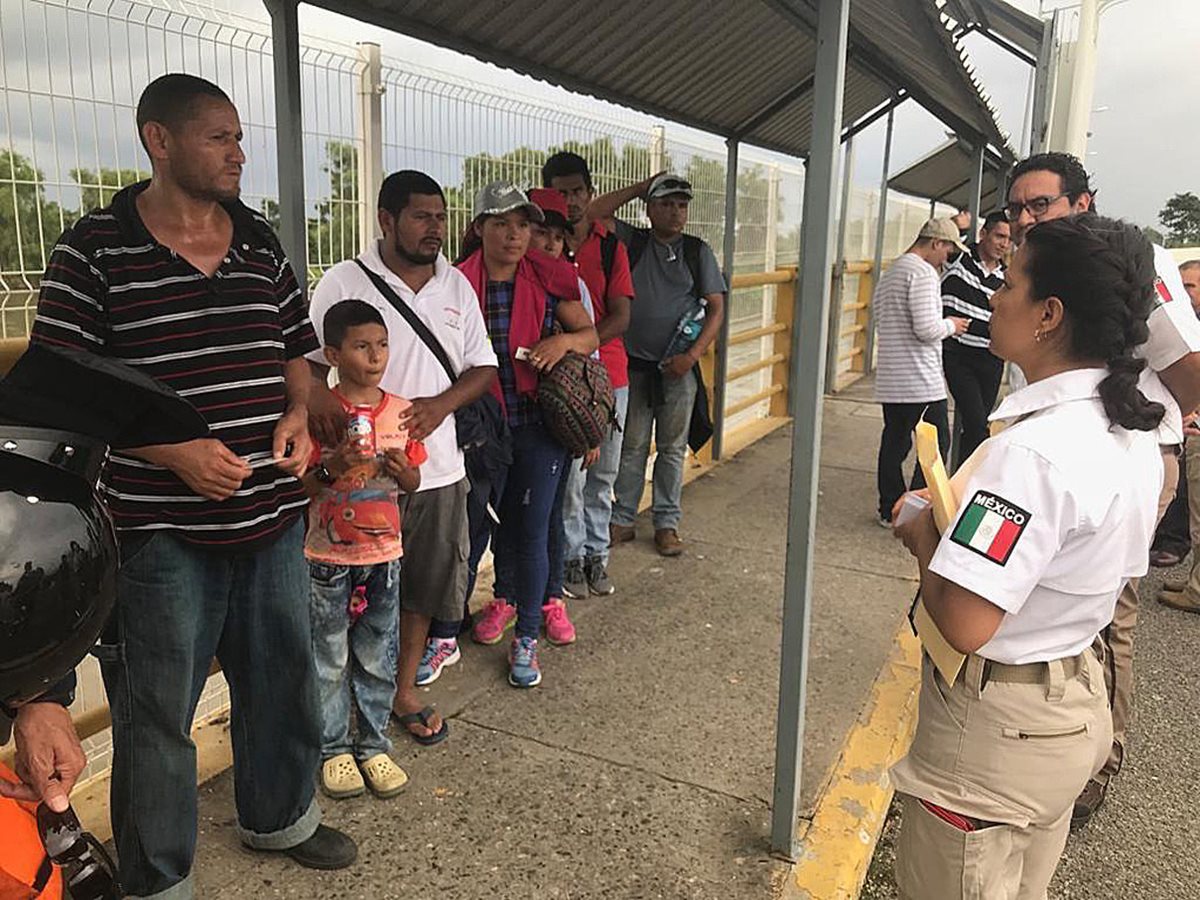 Personal del Instituto Nacional de Migración mexicano atiende a uno de los primeros grupos de nicaragüenses que llegaron a la frontera, después de un acuerdo para gestionar asilo. (Foto Prensa Libre: EFE)