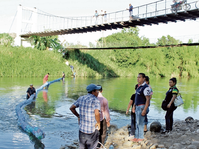 Personal del Ministerio de Ambiente instala la barrera que retendrá desechos plásticos. (Foto Prensa Libre: Oswaldo Cardona)