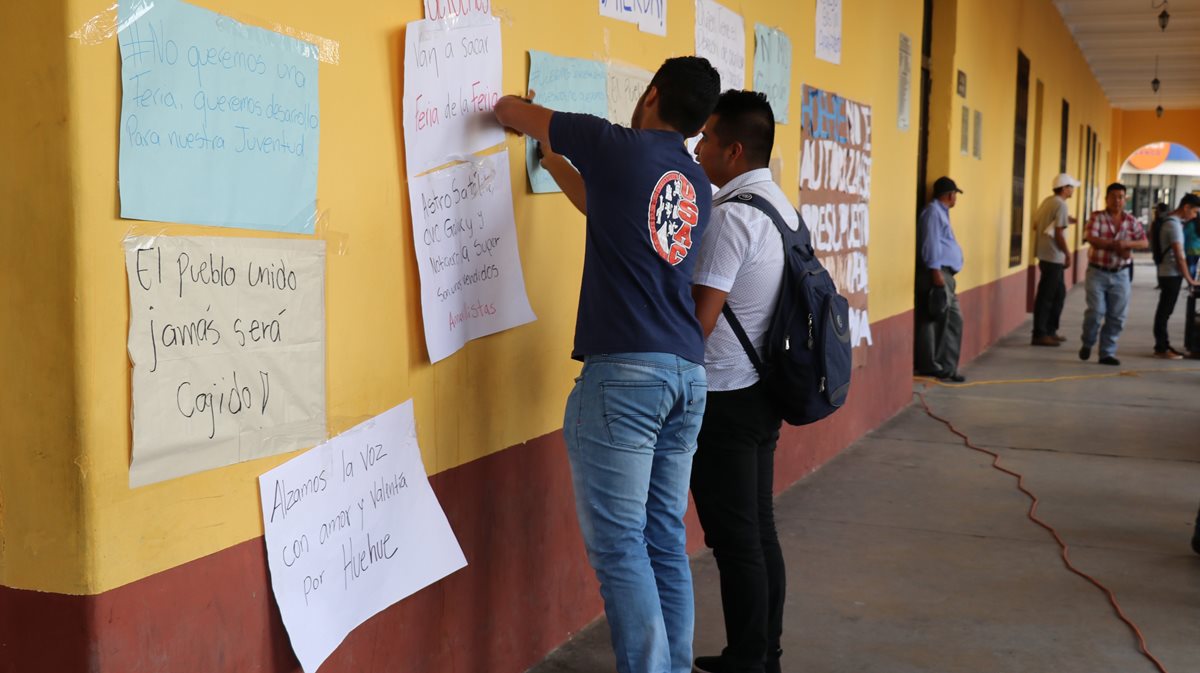 Estudiantes pegan rótulos en señal de protesta contra la administración municipal. (Foto Prensa Libre: Mike Castillo).