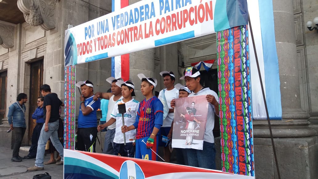 Integrantes del Colectivo Ciudadano colocaron este viernes un cartel en el parque central para que quienes participan en las actividades de Xelafer. (Foto Prensa Libre: Mynor Toc)