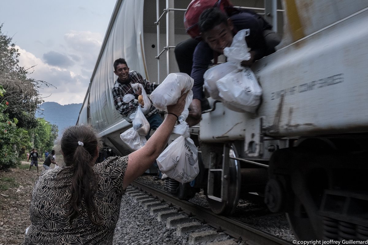 Una mujer de Las Patronas da alimentos a los migrantes que viajan en "la Bestia". (Foto: Las Patronas)