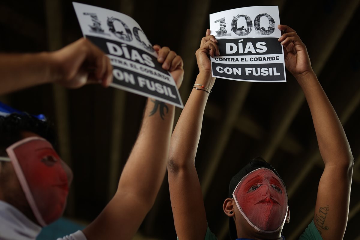Estudiantes enmascarados participan en una vigilia para conmemorar los 100 días de protestas contra el gobierno de Ortega. (AFP)