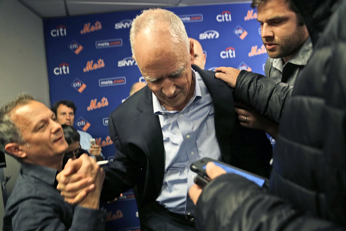 Sandy Alderson recibe apoyo de los reporteros para ponerse en pie luego de sufrir un desmayo. (Foto Prensa Libre: AP)