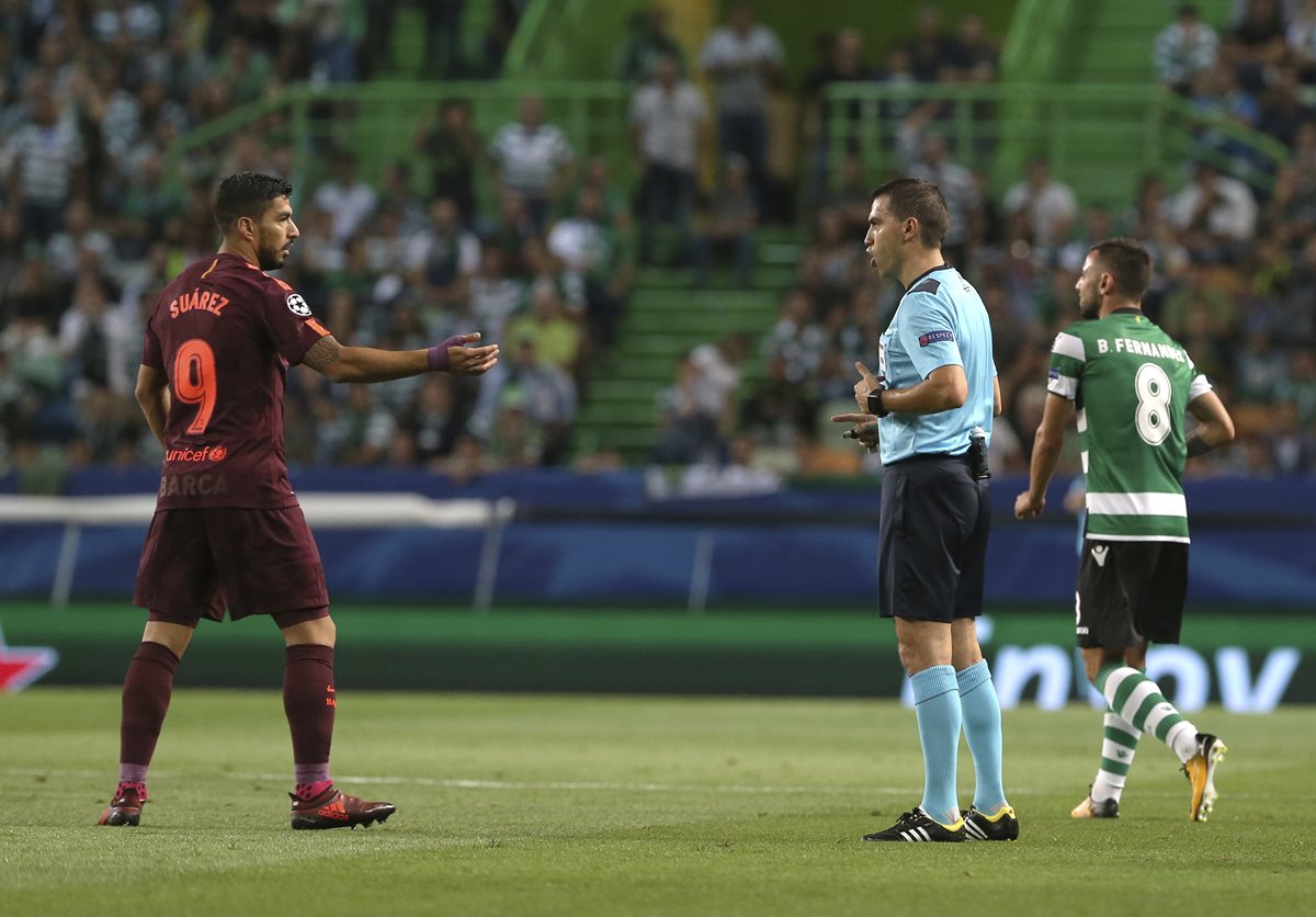 Luis Suárez habla con el árbitro en una acción del juego.