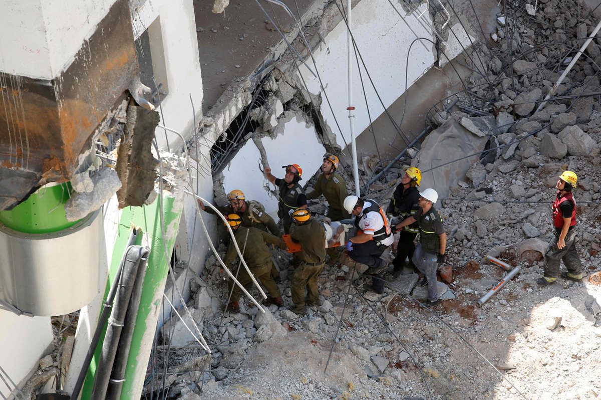 Bomberos buscan víctimas entre los escombros del aparcamiento. (Foto Prensa Libre: AFP).