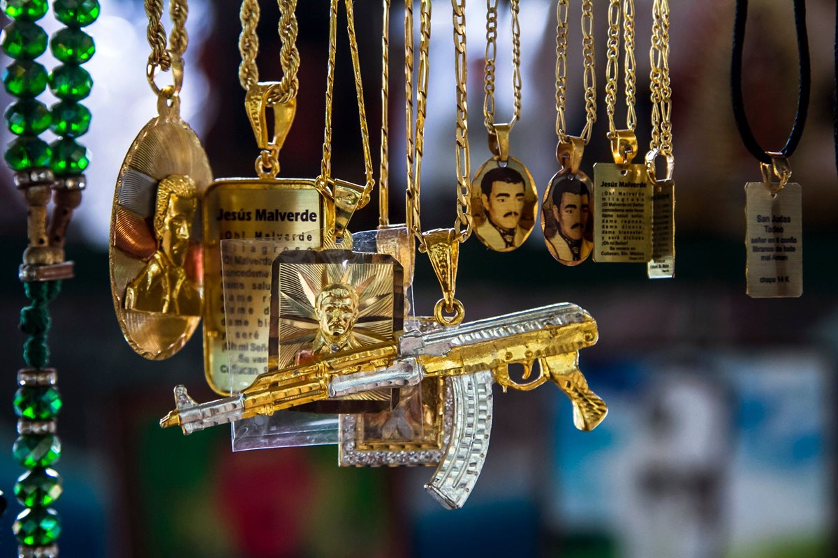 Cadenas con la figura del narco santo Jesús Malverde se exhiben a la venta en una capilla de Sinaloa. (Foto Prensa Libre: AFP)