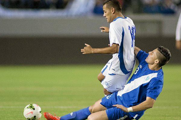 Elías Enoc Vázquez disputa el balón con Irvin Herrera de El Salvador, durante el duelo amistoso de este martes. (Foto Prensa Libre:  EFE)