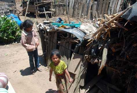 Jennifer Xiloj  García —izquierda—,  de 11 años, nacida en Estados Unidos,  en el patio de su precaria vivienda   en la aldea Chivarreto,   San Francisco El Alto, Totonicapán.