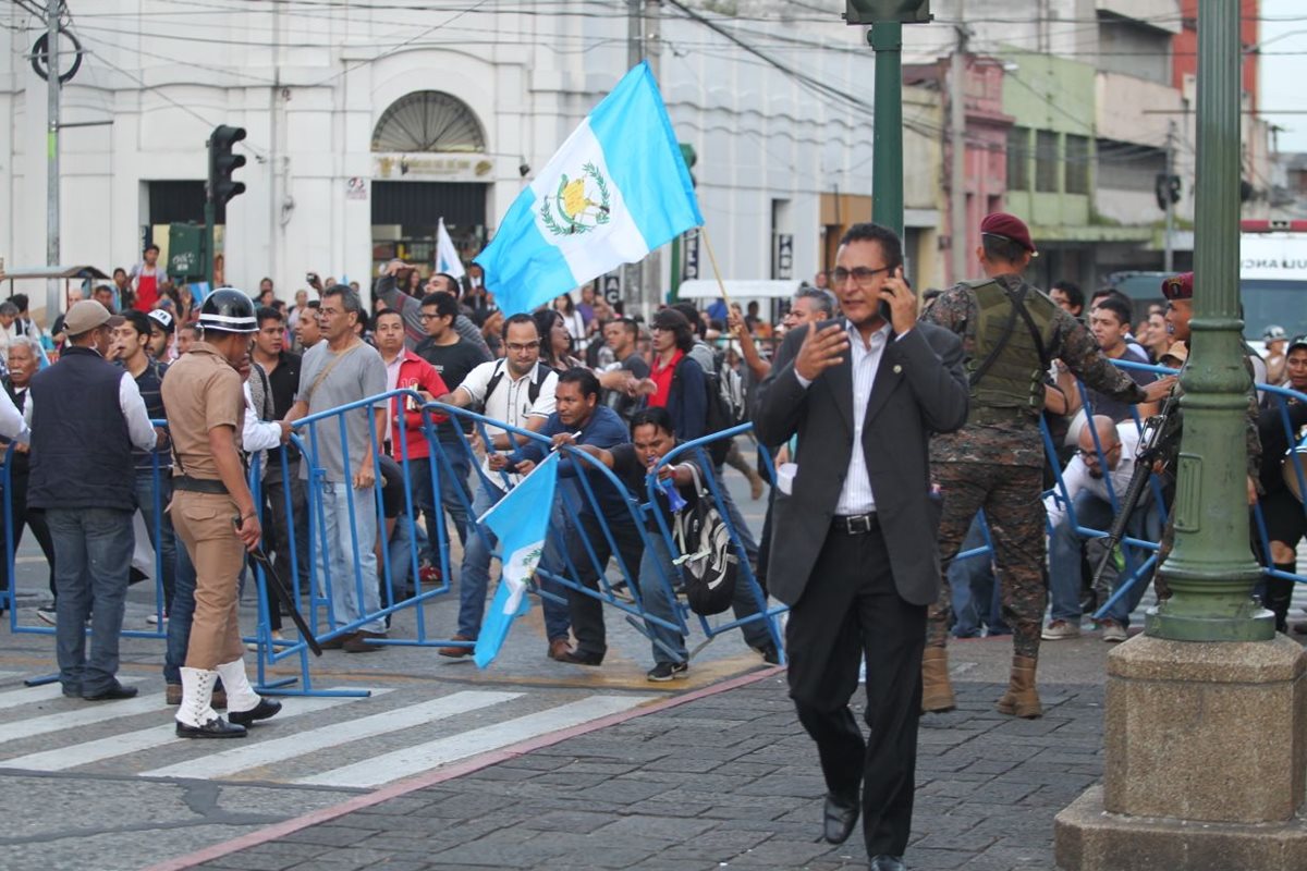 Momento en que manifestantes rompen el anillo de seguridad para irrumpir en el acto de Independencia. (Foto Prensa Libre: Carlos Hernández)