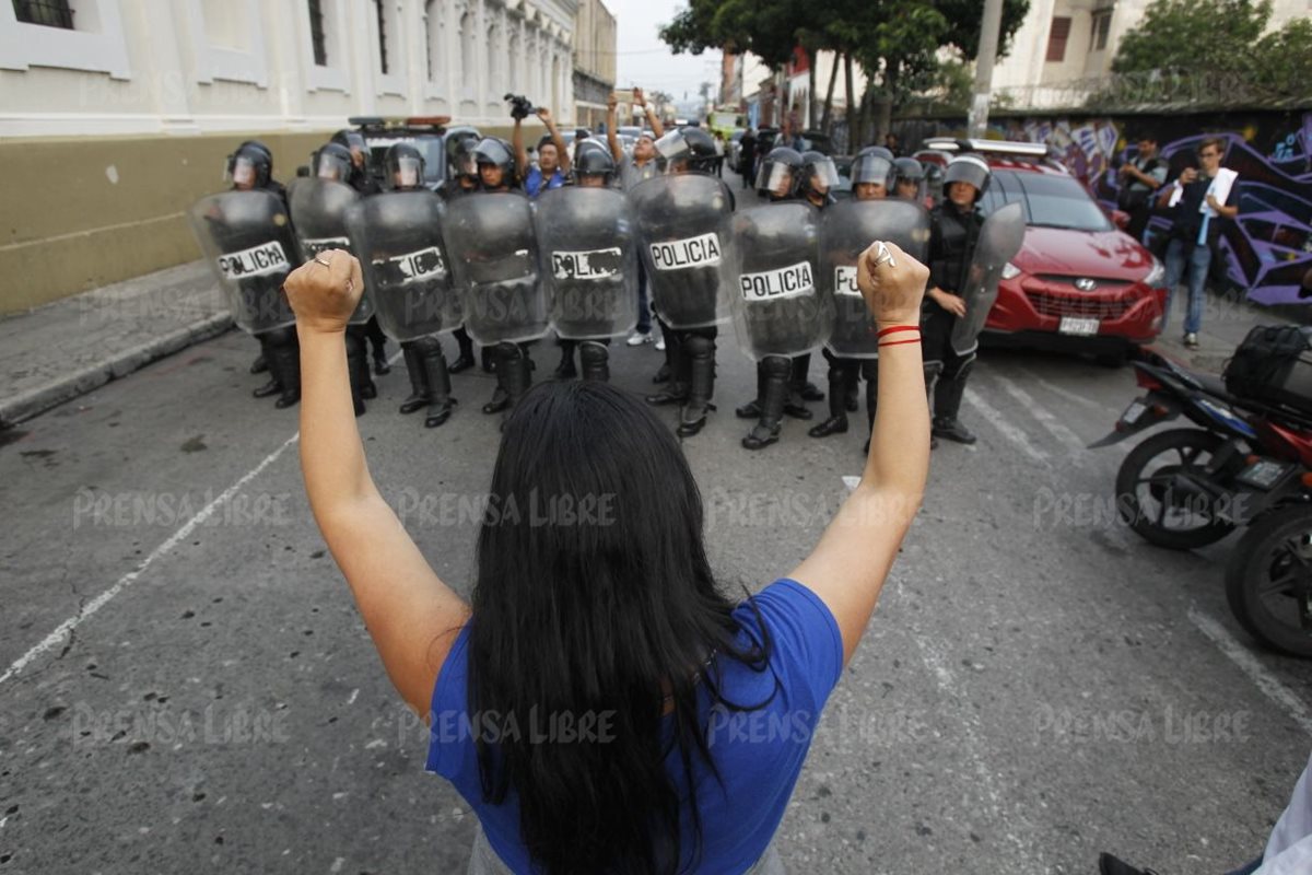 Mujer permanece frente a los antimotines