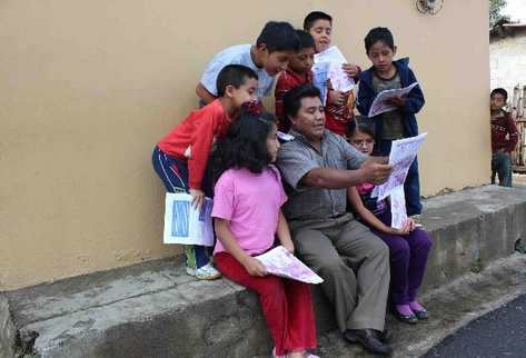 Un grupo de niños escuchan una de las historias que incluye la revista  Witzitzil,  editada por  Juan Yool.