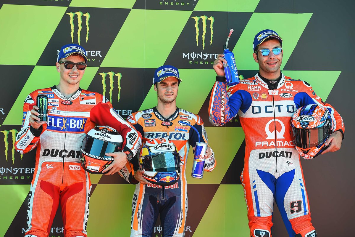 Dani Pedrosa (centro), junto a Jorge Lorenzo y Danilo Petrucci festejan luego de hacer el primero, segundo y tercer lugar en la clasificación del GP de Cataluña. (Foto Prensa Libre: AFP)