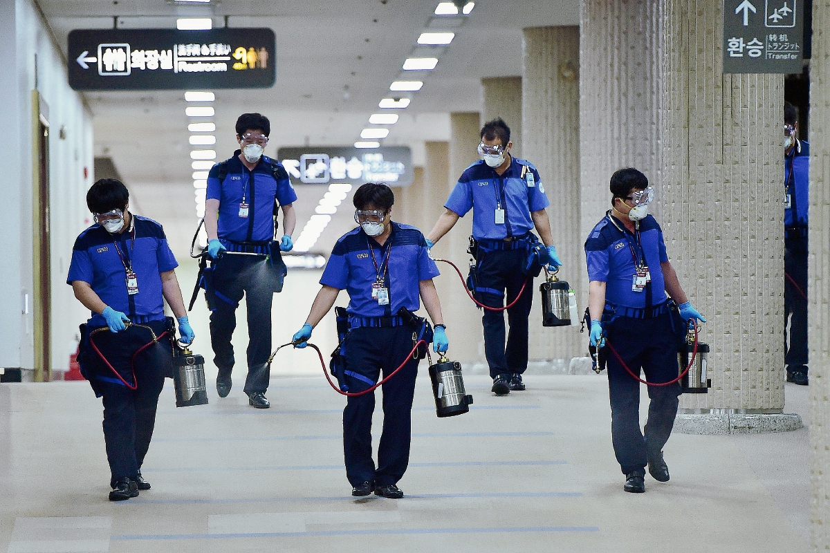 Trabajadores surcoreanos desinfectan el aeropuerto internacional de Gimpo en Seúl. (Foto Prensa LIbre:AFP)AFP