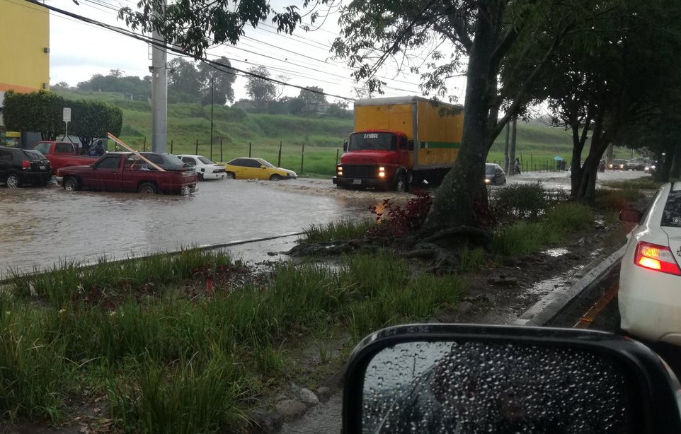 Vehículos pasan con dificultad por un tramo anegado de la colonia Atlántida, zona 18. (Foto Prensa Libre: @bosstruc)