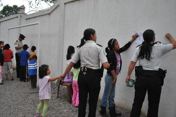 Agentes de la PNC, durante concurso  de dibujo en el hogar  Canica, en San Marcos.