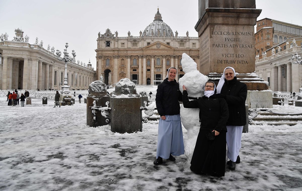 Monjas juegan con la nieve en la Plaza de San Pedro en el Vaticano. (Foto Prensa Libre: AFP)