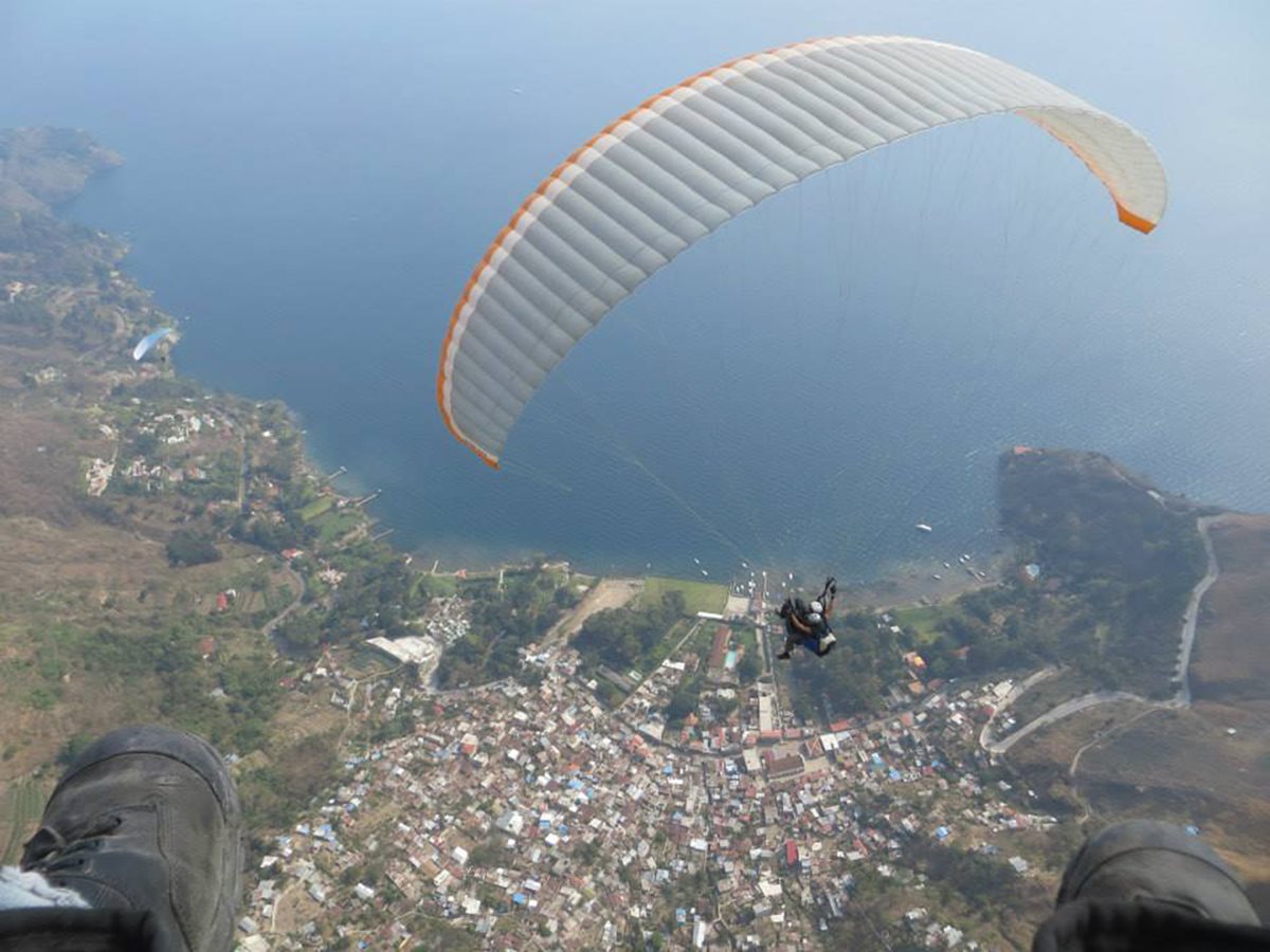 Fotografía hecha por un hombre que desciende hacia la playa de Panajachel en un parapente. (Foto Prensa Libre: Ángel Julajuj)