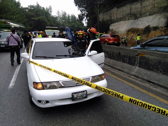 Investigadores de la PNC revisan el vehículo atacado a balazos en carretera a El Salvador. (Foto Prensa Libre: Estuardo Paredes)