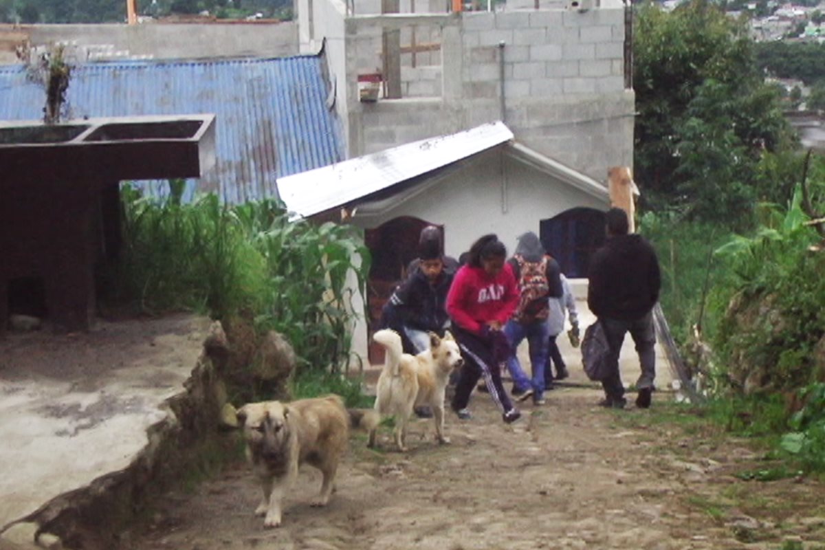 Familiares y vecinos llegan a la vivienda de los padres del agente ultimado para darles el pésame. (Foto Prensa Libre: Whitmer Barrera)