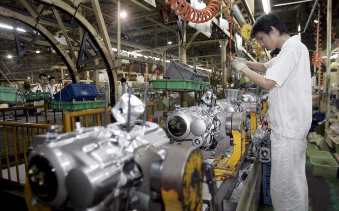 Un trabajador en la línea de producción de motores de la fábrica de motocicletas Jia Ling en Chongqing, China.(Foto Prensa Libre: EFE)