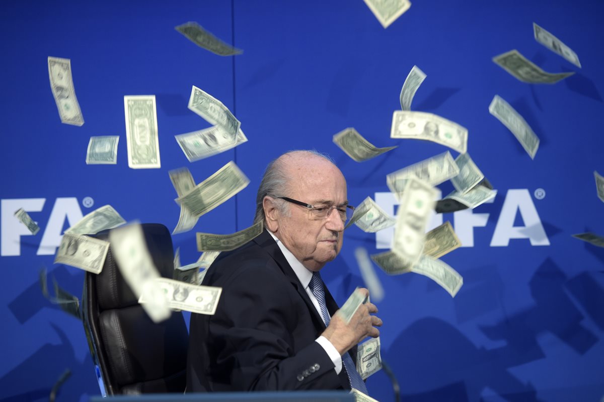 Joseph Blatter fue "bañado" en dólares durante una conferencia de prensa. (Foto Prensa Libre: AP)