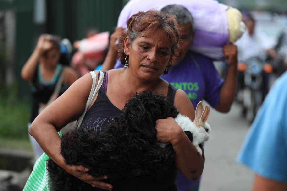 Sin olvidar a sus mascotas una mujer corre hacia el centro de Escuintla.