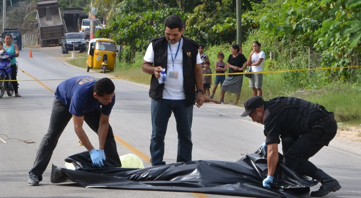 Autoridades retiran el cuerpo sin vida de Oscar René Tec Sacul de la calle. (Foto Prensa Libre: Rigoberto Escobar)