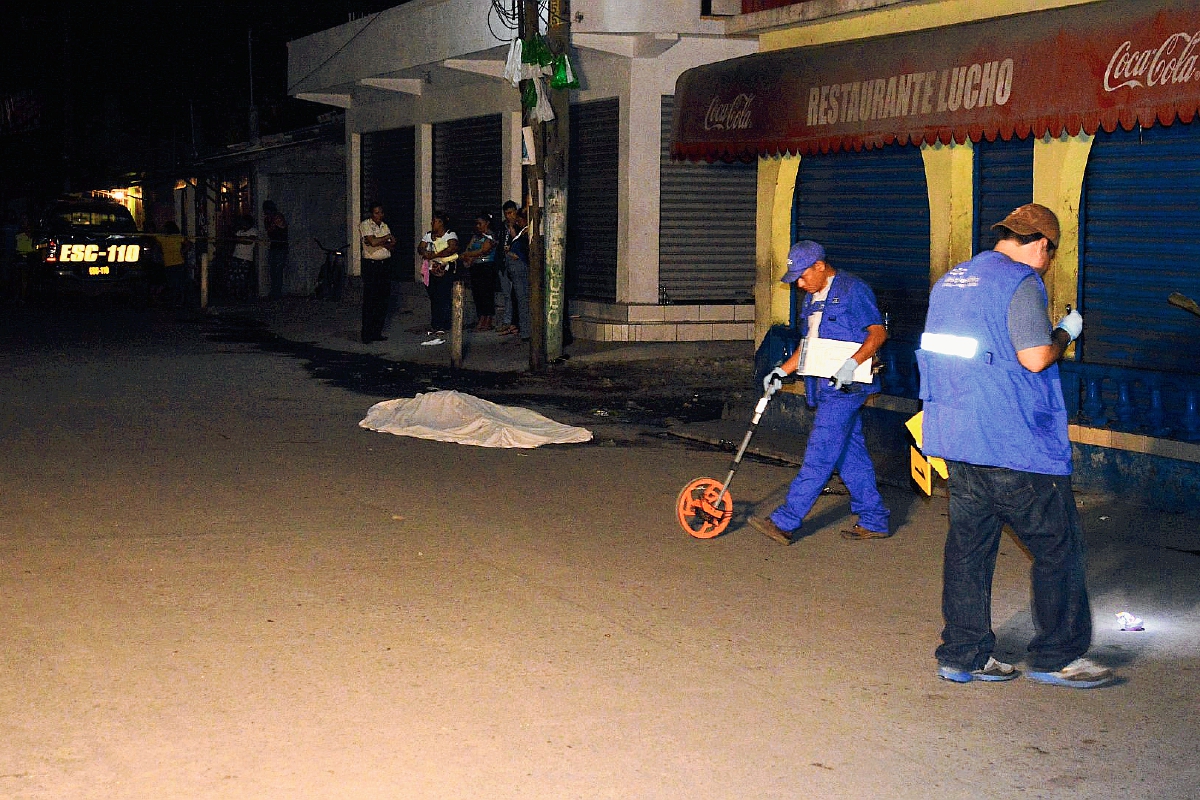 Investigadores reúnen evidencias en el lugar donde murió baleado Isaí García, en Puerto San José. (Foto Prensa Libre: Enrique Paredes)