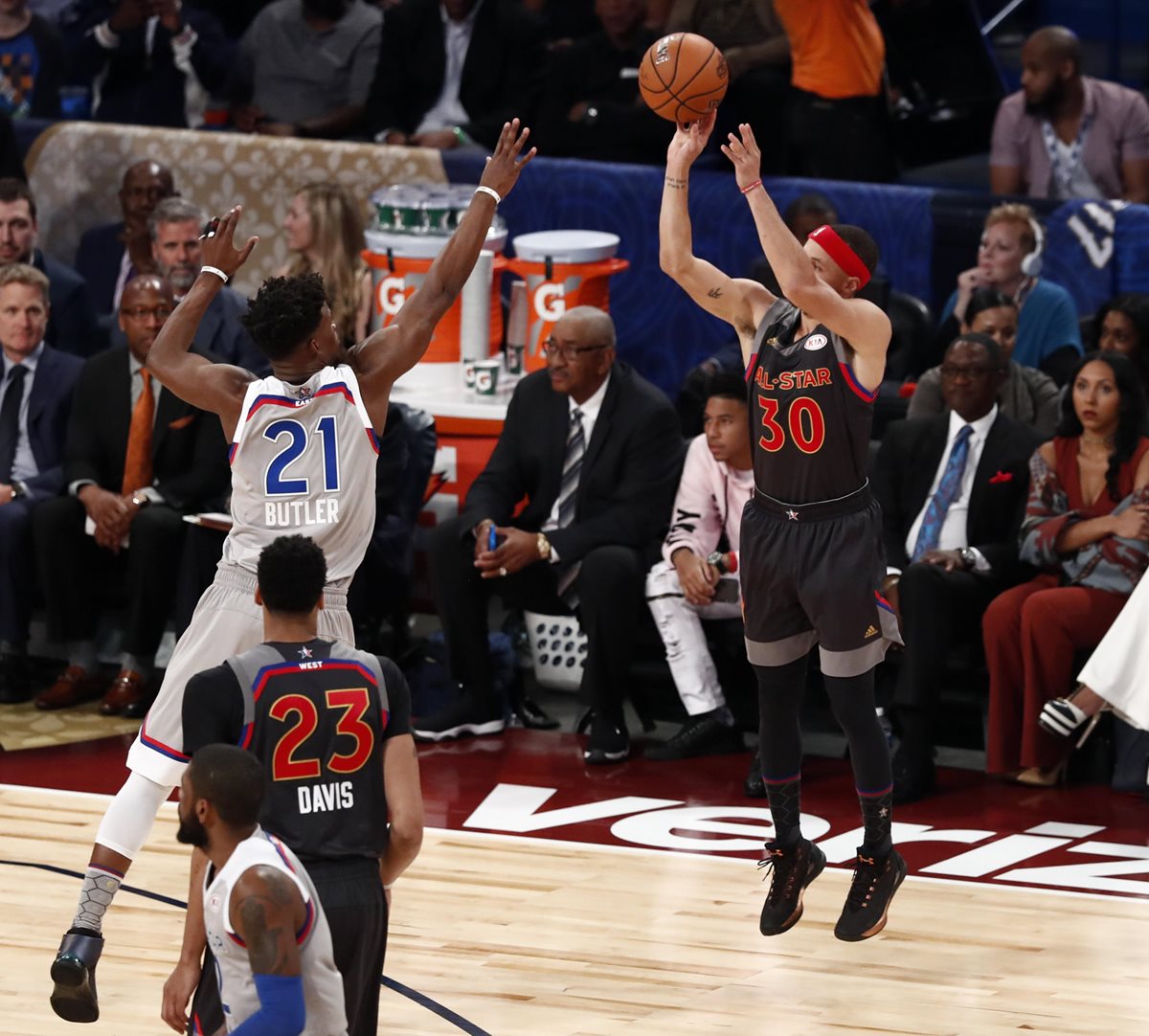 Curry anota ante la marcación de Butler durante el juego de esta noche. (Foto Prensa Libre: EFE)