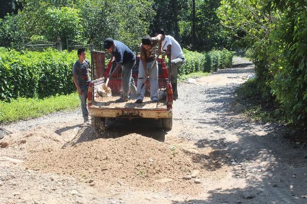 Vecinos trabajan  en camino de Tiquisate.