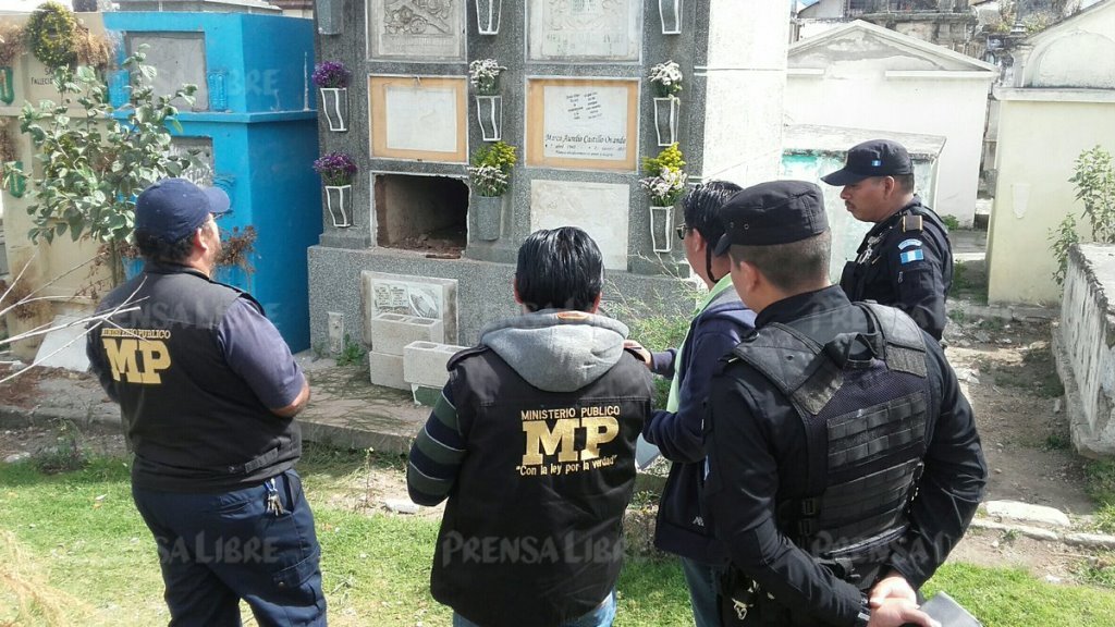 Investigadores observan tumba profanada en camposanto de Xela. (Foto Prensa Libre: Carlos Ventura).