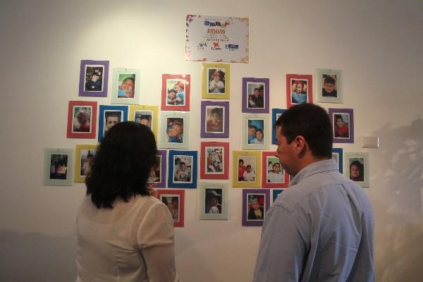 visitantes observan un mural que recuerda a algunos de los pacientes del hospicio.