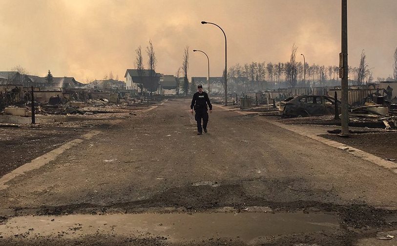 Un oficial de policía camina por las calles de Fort McMurray, que ha quedado devastada por el fuego. (Foto Prensa Libre: AP).