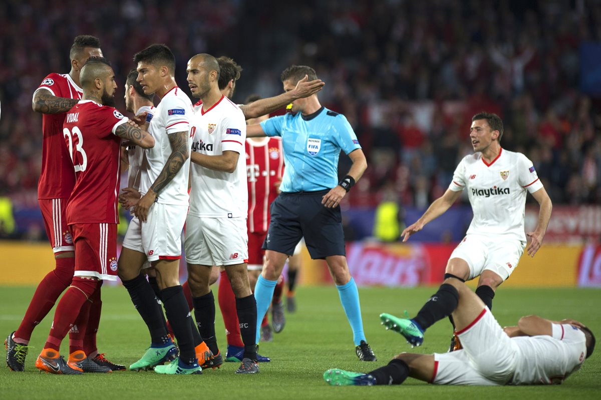 Jugadores del Sevilla y el Real Madrid discuten después de una entrada fuerte contra un jugador del cuadro español. (Foto Prensa Libre: AFP)