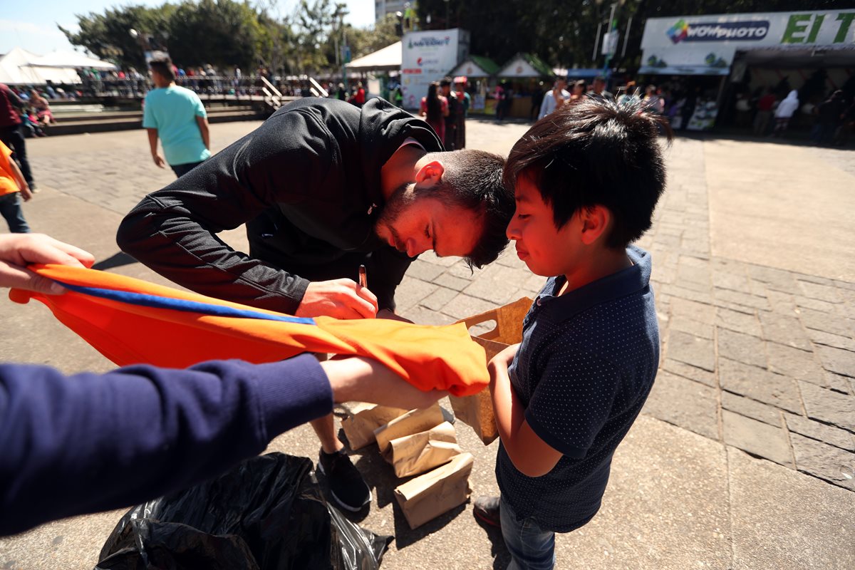 Rodrigo Saravia firma una de las camisolas que regaló. (Foto Prensa Libre: Jeniffer Gómez)