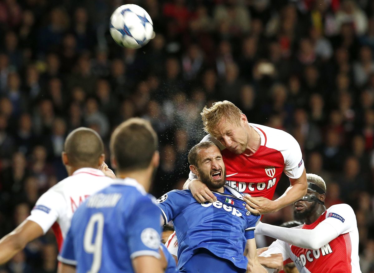 Kamil Glik del Mónaco intenta un remate de cabeza frente al italiano Giorgio Chiellini.