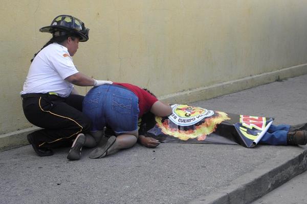 Familiar llora sobre cadáver de Fredy Jacky Smith de Paz, muerto a balazos frente a la iglesia Luterana en el barrio San Marcos, de la cabecera de Zacapa. (Foto Prensa Libre: Julio Vargas)