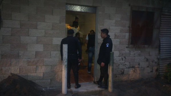 Agentes de la Policía Nacional Civil inspeccionan una vivienda en la aldea Las Trojes, Amatitlán. (Foto Prensa Libre: PNC)