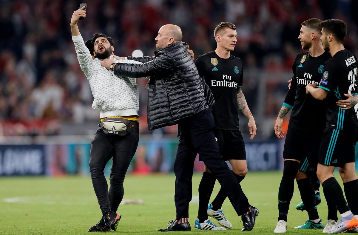 Un asistente de campo detiene a un aficionado en el estadio Allianz Arena en Munich (Alemania). (Foto Prensa Libre: EFE)