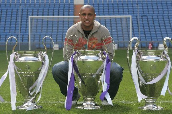 El defensa brasileño Roberto Carlos muestras las copas que ganó con el Real Madrid en la Liga de Campeones. (Foto Prensa Libre: AS Color)