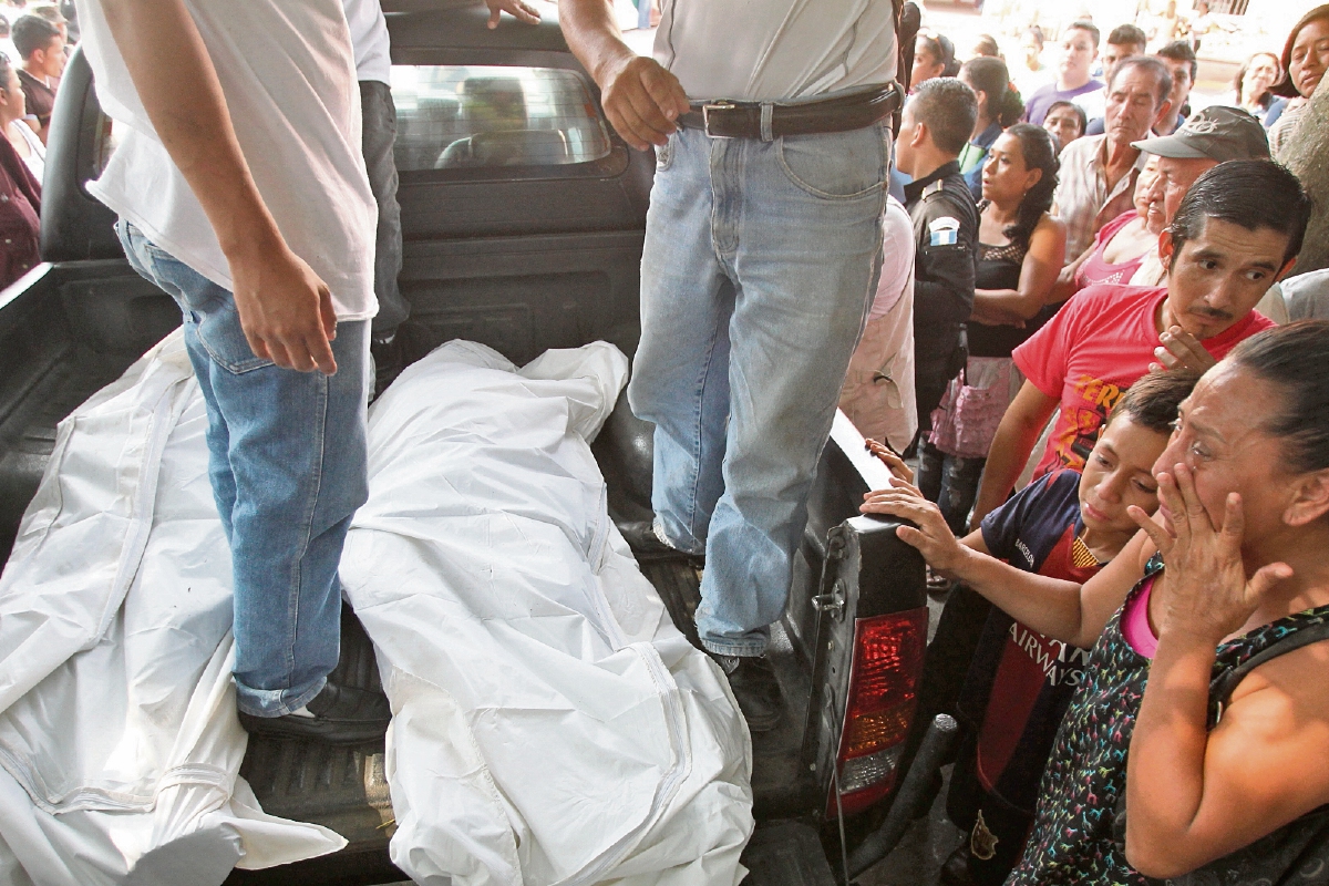 PERSONAL DEL Ministerio Público traslada los cuerpos de los periodistas Danilo López y Federico Salazar a la morgue de Mazatenango, ante escenas de llanto y dolor de familiares y amigos congregados en el lugar del ataque.