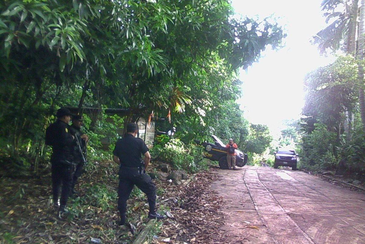 Agentes de la PNC resguardan una de las viviendas allanadas en El Asintal, Retalhuleu. (Foto Prensa Libre: Jorge Tizol)