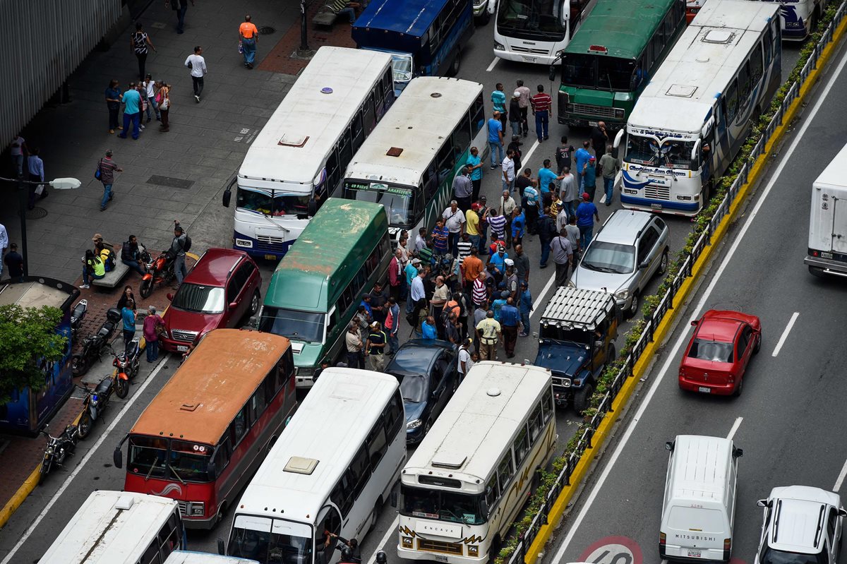 Los conductores de autobuses del sistema de transporte público bloquearon una avenida principal en Caracas este viernes para protestar contra la escasez de repuestos para sus vehículos. (Foto Prensa Libre: AFP)