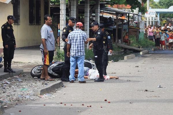 Policías hablan con testigos de crimen.